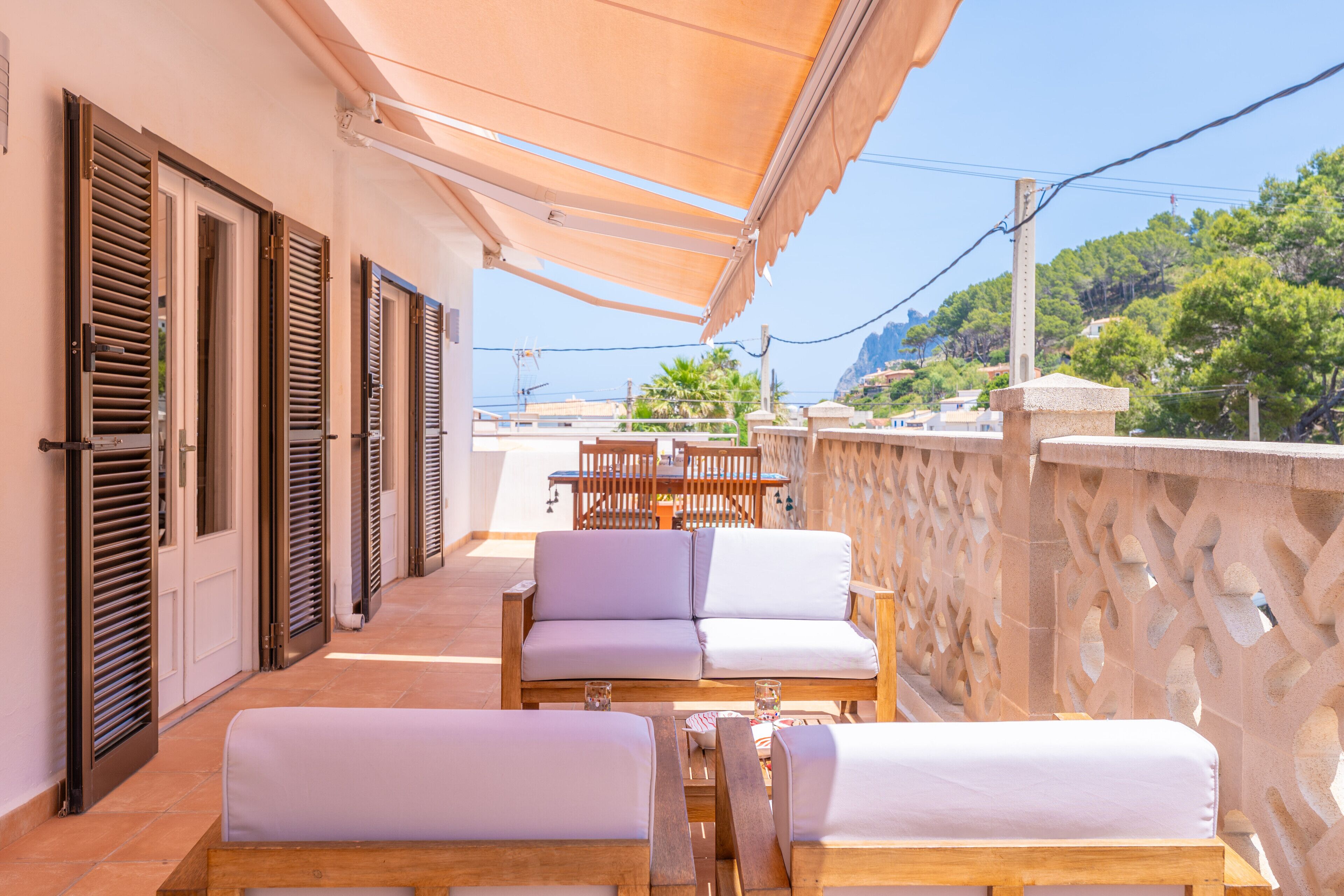 A terrace with wooden furniture, a table, and a sofa.