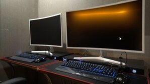 A dual-monitor setup with a curved monitor and a flat monitor, a mechanical keyboard, a mouse, and a gaming mouse on a desk. - Bucheon THE Play (Bucheon)