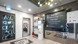 A hotel lobby with a reception desk, guest rooms, and a fire extinguisher. - Cheonan DRAPA Hotel (Cheonan)