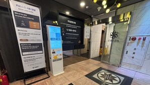 A hotel lobby with a kiosk for room reservations, a fire extinguisher, and a security camera. - Cheonan DRAPA Hotel (Cheonan)