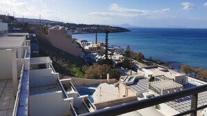 A coastal residential area with modern buildings, a swimming pool, and a view of the sea. - Valeria Sea View Apartment in Rethymno, Crete (Rethymno)