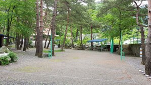 Un espace recouvert de gravier, agrémenté d’arbres et doté d’un espace de repos abrité.
