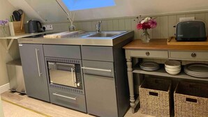 A compact kitchen with a skylight, a built-in oven, and a toaster on a wooden countertop. - Cosy Rural Retreat, Sleeps 3 & PetFriendly (Pewsey)