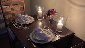 A dining table set with plates, cutlery, glasses, and candles, with a chair in the foreground. - Cosy Rural Retreat, Sleeps 3 & PetFriendly (Pewsey)
