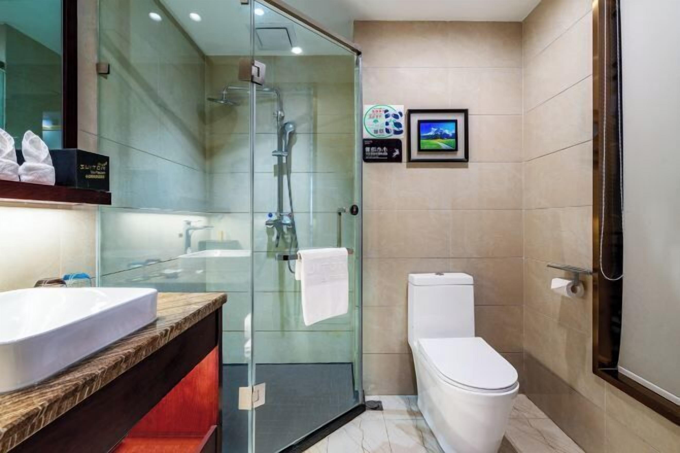 Ein modernes Badezimmer mit einer Duschkabine, einer weißen Toilette und einem Holzwaschtisch.