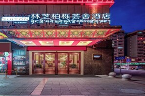 A hotel entrance with a traditional design, featuring a large glass door and a sign above. - Suiton Plus By Paxton Linzhi (Nyingchi)