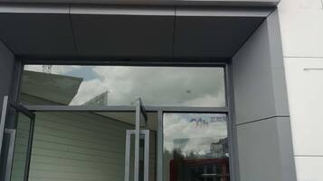 A bank entrance with a glass door and a sign indicating self-service banking.