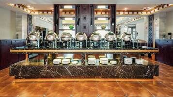 A hotel lobby with a marble reception desk, multiple coffee machines, and a glass display case.