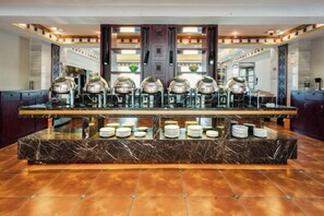 A hotel lobby with a marble reception desk, multiple coffee machines, and a glass display case. - Suiton Plus By Paxton Linzhi (Nyingchi)