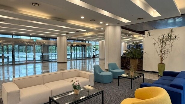 Een moderne lobby met een bank, fauteuils en een salontafel.