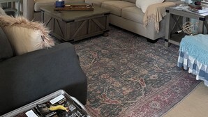 A living room with a ceiling fan, a large painting, a sofa, a coffee table, and a patterned rug. - Shawnee Creek Hideaway - Close to Eminence and the Jacks Fork River! (Winona)