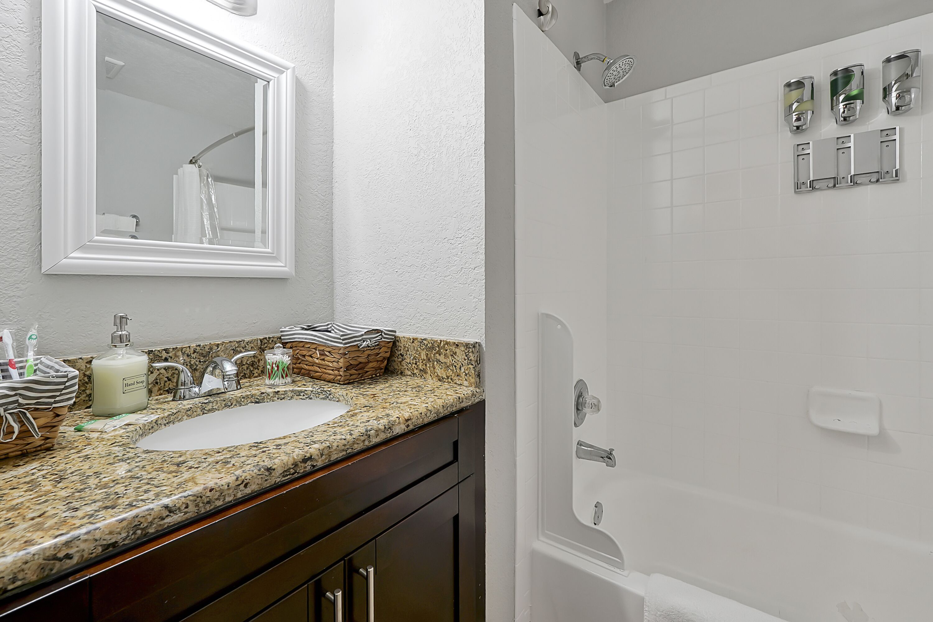A bathroom with a double sink, a large mirror, a shower with a glass door, and a towel rack.