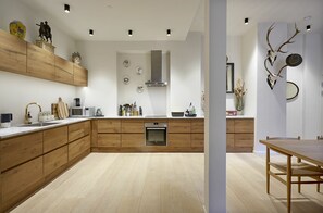 Eine moderne Küche mit Holzausstattung, Edelstahlgeräten und einer zentralen Kochinsel.