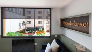 Ein modernes Zimmer mit einem großen Fenster, einer Couch und einem Schild mit der Aufschrift 'Patio de Graci'.