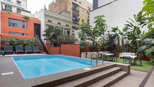 Ein rechteckiger Pool mit Stufen, umgeben von einer Holzterrasse.
