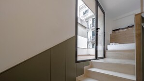 Eine Treppe mit Blick auf einen Balkon und ein Bett.