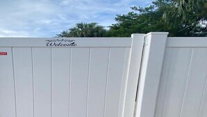 A white gate with a 'Welcome' sign and a red sign indicating a private property. - Romantic Guest Suite - Near Downtown & Stadium - High-Speed WiFi (Tampa)