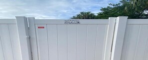 Una puerta blanca con un cartel de 'Welcome' y un letrero rojo que indica propiedad privada.
