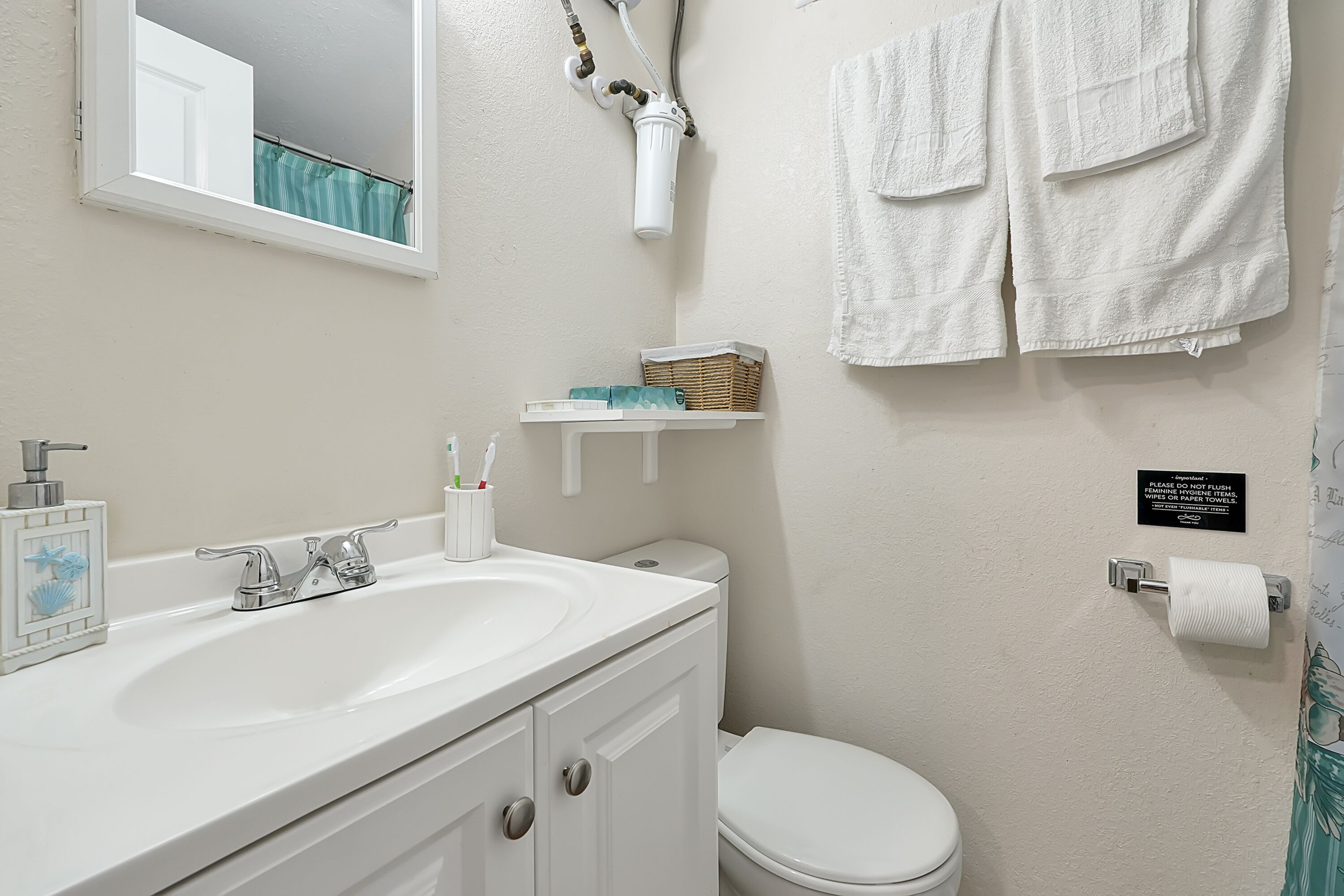 Een badkamer met een wit wastafel, een toilet en een handdoekrek.