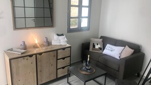 Una sala moderna con un aparador de madera, un sofá gris y una mesa de centro.