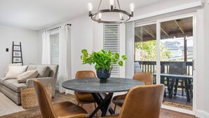 A dining area with a round table, four chairs, a potted plant, and a chandelier. - Sensationally Furnished *Hot Tub*, Pet Friendly, Game Room w/ Ping Pong, Foosball, Darts, Etc (Vancouver)