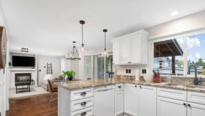 A modern kitchen with white cabinetry, granite countertops, and pendant lighting. - Sensationally Furnished *Hot Tub*, Pet Friendly, Game Room w/ Ping Pong, Foosball, Darts, Etc (Vancouver)