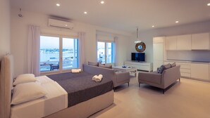 Une chambre d ’hôtel moderne, dotée d’un grand lit, d’un canapé, d’une télévision et offrant une vue sur la ville.