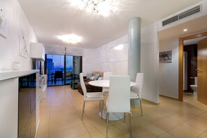 A modern kitchen with white cabinets, a built-in oven, and a large window.