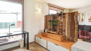 A modern living room with a wooden bench, a potted plant, and a striped chair. - Atico Los Condes by Hello Homes Sitges (Sitges)