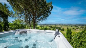 A hot tub with a panoramic view of a lush landscape.