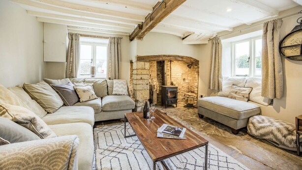 A cozy living room with a stone fireplace, a sofa set, and a coffee table. - Beautifully presented dog friendly holiday cottage in the Cotswolds with a courtyard garden - Heath (Stow-on-the-Wold)
