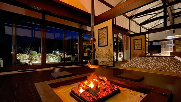 Un interior moderno con chimenea, ventanas amplias y vistas al exterior.