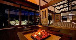 Un interior moderno con chimenea, ventanas amplias y vistas al exterior.