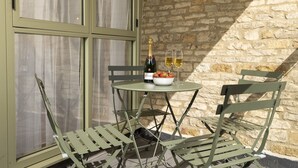 A table with a bottle of champagne, two glasses, and a bowl of strawberries. - The Staircase -  luxury dog friendly home in Stow on the Wold (Stow-on-the-Wold)