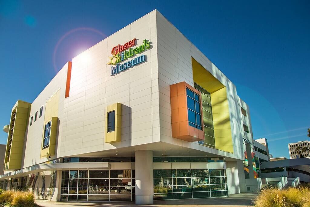 The exterior of the Glazer Children's Museum, featuring a modern architectural design with large glass windows and a prominent signage.