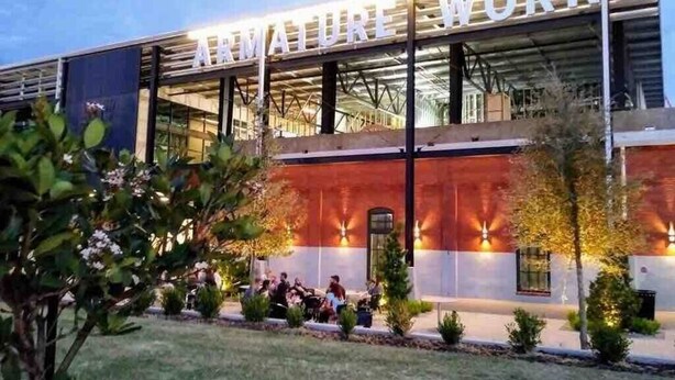 A building with the sign "ARMATURE WORKS" and a group of people sitting outside. - Cozy Studio Bungalow Walk to Armature and Downtown (Tampa)