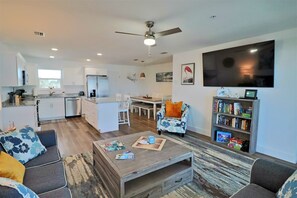 Un salon moderne avec un canapé, une table basse et une bibliothèque.