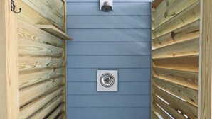 Un'angusta struttura in legno con una parete blu e un oggetto circolare bianco appeso al muro.