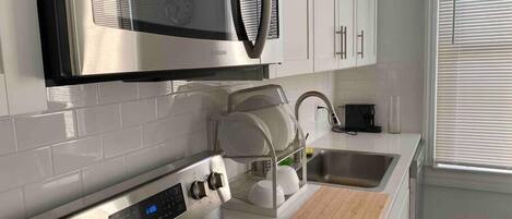 A modern kitchen with stainless steel appliances, a microwave, a built-in oven, and a sink.