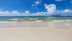 Une plage avec un ciel dégagé et des vagues.