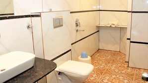 A bathroom with a toilet, sink, and shower area. - Hotel Pachmarhi (Pipariya)