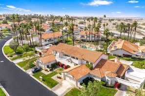A residential area with houses featuring red-tiled roofs, surrounded by palm trees. - Near Coachella | Desert Falls Home | Steps to Pool, Spa, & Fun! Mountain Views Out Your Window! (Palm Desert)