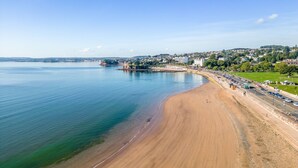 A coastal beach with a wide sandy shore, a calm sea, and a cityscape in the background. - De'nada, Vernon Court -  an apartment that sleeps 2 guests  in 1 bedroom (Torquay)