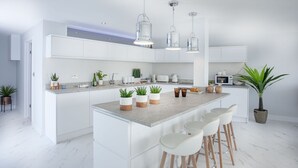 A modern kitchen with white cabinetry, a marble countertop, and pendant lighting. - De'nada, Vernon Court -  an apartment that sleeps 2 guests  in 1 bedroom (Torquay)