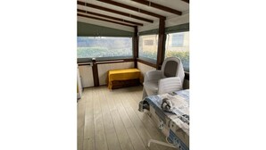 A small cabin room with a bed, a bench, and a chair. - Mobile home for 6 people. (Arvert)