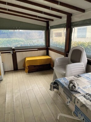 Una habitación tipo cabaña con una cama, un banco y una silla.
