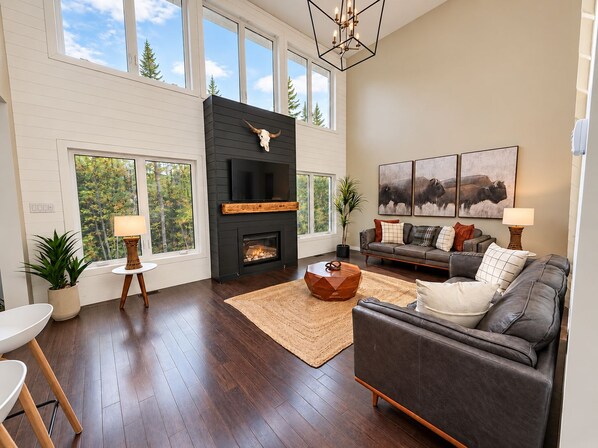 A modern living room with a fireplace, a sofa, a coffee table, and artwork on the wall.