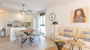 A modern apartment with a kitchen, dining area, and living room.