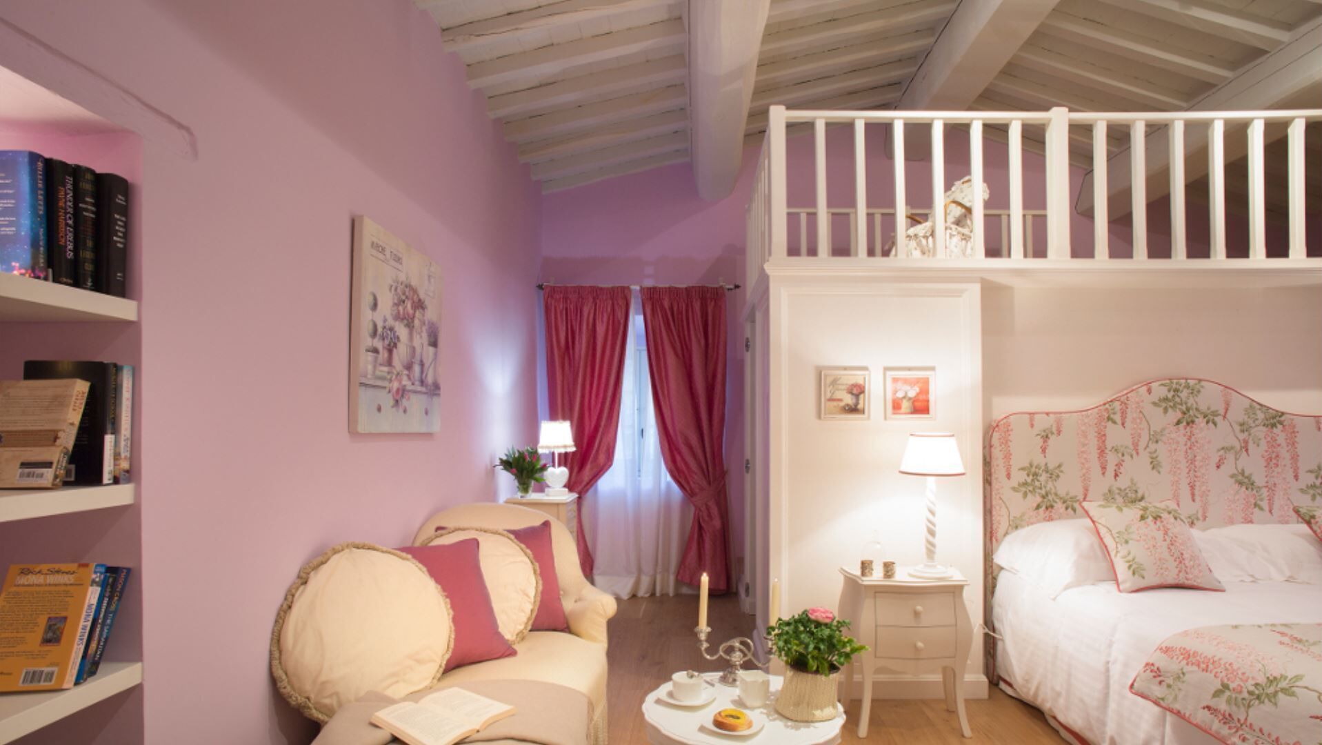 A cozy bedroom with a bed, a nightstand, a bookshelf, and a window with curtains.