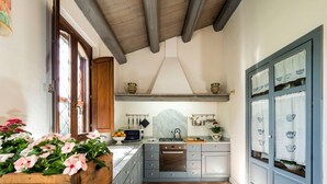 Une cuisine avec un plafond en bois, une cuisinière et un évier.